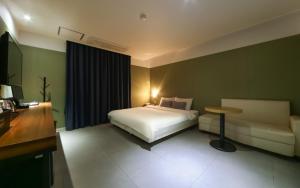 釜山Yeonsan Oops Hotel的一间卧室配有一张床、一张桌子和一张沙发