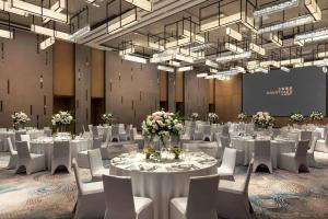 深圳深圳湾万怡酒店的一间会议室,配有白色的桌椅和吊灯