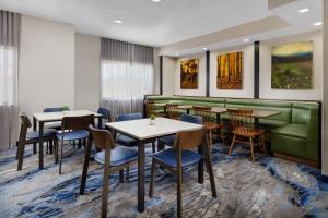 费城菲尔菲得旅舍由万豪费城机场酒店的餐厅设有桌椅和绿色沙发