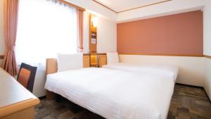 旭川Toyoko Inn Hokkaido Asahikawa Ekimae Ichijo dori的酒店客房设有两张床和窗户。