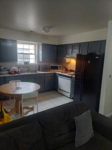 纽瓦克Crystal Room 1 Guest House near 12mins to EWR airport / Prudential / NJIT / Penn station的厨房配有黑色冰箱和桌子