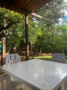 戈亚斯州上帕莱索Pousada Recanto dos Sonhos的凉棚下一张白色桌子和两把椅子