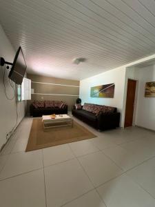卡诺格布拉达My House Canoa的客厅配有两张沙发和一台电视机
