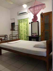 阿努拉德普勒Feel Like Home Anuradhapura的一张床上有粉红色伞的床