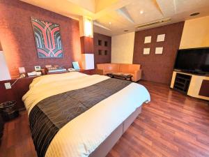 大村市SKY Ocean-terace Omura的一间卧室配有一张大床和一台平面电视