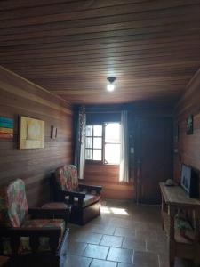 里奥格兰德Casa na Praia do Cassino.的房屋内的房间,配有两把椅子和一扇窗户
