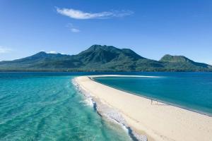 曼巴豪Playa del Fuego Camiguin Beach Hostel & Resort的一片空旷的海滩,背靠山