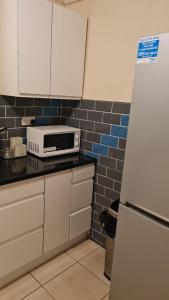 伯明翰3BED Maisonette Near CityCentre的厨房配有白色冰箱和微波炉