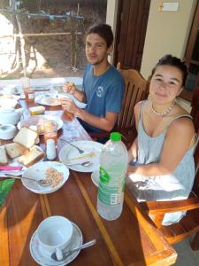 坦加拉Appu Villa的坐在餐桌旁吃食物的男人和女人