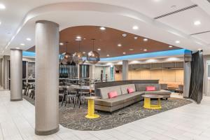 达拉斯SpringHill Suites Dallas Central Expressway的一个带沙发和桌子的大堂以及一间餐厅