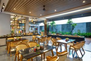 日惹Kinaralana Hotel Yogyakarta的一间带桌椅的餐厅和一间酒吧