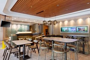 奥卡拉SpringHill Suites by Marriott Ocala的一间带桌椅的餐厅和一间酒吧