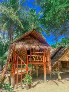 Ko PorMalee homestay的海滩上的小屋,棕榈树