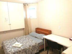 沃恩Soho, Comfortable with Free Parking Spot on basement的小房间设有一张床和一张书桌