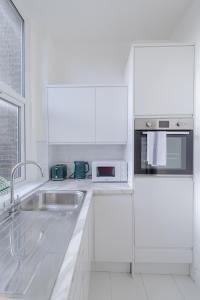 伦敦HAFH in Paddington - Double studio 1的白色的厨房配有水槽和微波炉