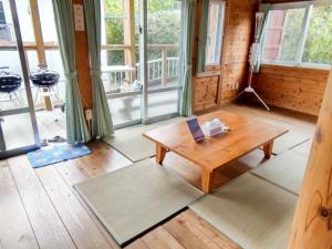 西表岛伊鲁蒂幅塔梅穆拉山林小屋的客厅配有木桌和窗户。