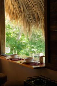 特隆戈内斯Surf Lodge at Casa Mexibali, Troncones的窗前带杯子和碟子的桌子
