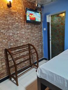 阿努拉德普勒JD Resort的砖墙上设有长凳和电视的房间