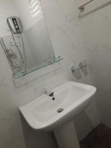 阿努拉德普勒JD Resort的白色的浴室设有水槽和镜子