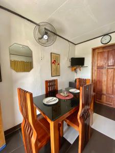 莫阿尔博阿Panagsama Holiday Cottage的一间用餐室,配有黑色的桌子和椅子