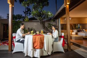 塞米亚克阿萨巴厘岛豪华别墅及Spa酒店的坐在桌子上的男人和女人