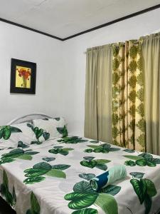 莫阿尔博阿Panagsama Holiday Cottage的一间卧室配有一张带绿色和白色毯子的床