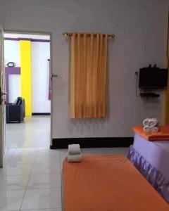 巴厘巴板Pavillion EMWEKA Balikpapan的一间设有床的房间和一个带窗帘的门