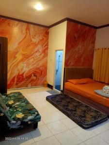 巴厘巴板Pavillion EMWEKA Balikpapan的卧室配有一张床,墙上挂有绘画作品