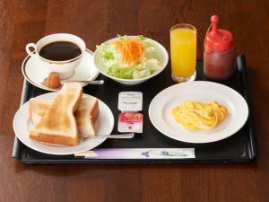 富士市Tabist Hotel New Central的盘子,盘子上放着早餐食品和咖啡
