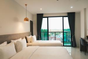 班武里府Mountain&Sea Hotel Prachuap的带阳台的酒店客房内的两张床