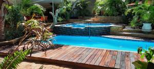 奔巴岛R A GUEST HOUSE PEMBA的花园内的游泳池,设有木甲板