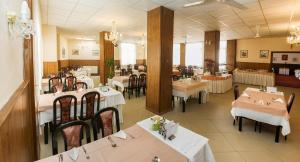 皮耶什佳尼Ensana Vila Trajan的一间设有白色桌椅的用餐室和一间餐厅