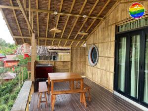 Ban Rak ThaiHedreung banrakthai homestay and camping的木甲板,配有桌子和长凳