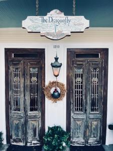 新奥尔良The Dragonfly Guest House的两扇门的房子,上面有标志