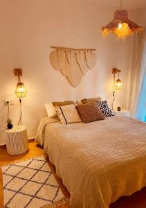 卡拉菲格拉Can Somni - Appartement bohème, zen et chic avec piscine的一间卧室配有一张大床和一个吊灯。