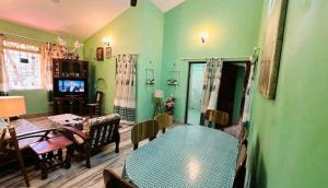 马焦茹达La Des Chateau Holiday Suites的客厅设有绿色的墙壁和桌子