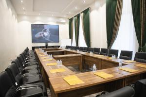 塔什干Hotel Marwa Tashkent Pool&Spa的一间会议室,配有木桌和黑椅子