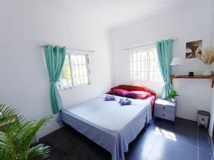 高龙撒冷岛Sam's Guesthouse M'Pai Bay的一间卧室设有一张床和两个窗户。