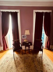 新奥尔良The Dragonfly Guest House的客厅配有红色窗帘和桌椅