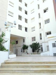 El AouinaJARDIN Apartments的前面有楼梯的大型白色建筑