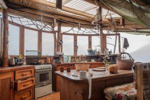 圣马科斯拉拉古纳Earthship amazing Cabins with lake view的厨房配有桌子和炉灶,部分设有窗户。