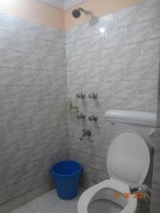 加尔各答Khaja Hotel的一间带卫生间和蓝色桶的浴室