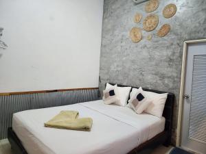 沙美岛Baan Minnie 3 bedroom house 400m from Saikaew beach的卧室配有白色的床和帽子