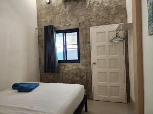 沙美岛Baan Minnie 3 bedroom house 400m from Saikaew beach的一间卧室设有床、窗户和门