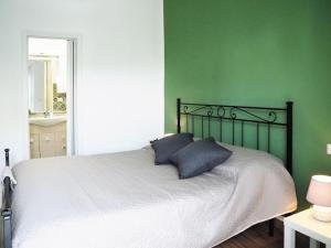 斯波托尔诺HOTEL RESIDENCE VILLA NINA的一间卧室设有绿色的墙壁和一张带两个枕头的床