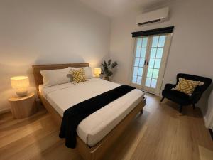 英厄姆Sans Souci Apartments的卧室配有床、椅子和窗户。
