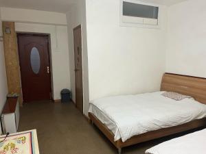 乌兰巴托加纳旅馆的一间卧室配有一张床,一扇门设有窗户