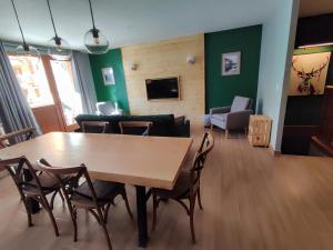 蒂涅Luxueux appartement T4 skis aux pieds à Tignes le Lac的客厅配有木桌和椅子