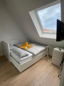 纽伦堡Spielwarenmesse Unterkunft的一间卧室配有带橙色带子的床