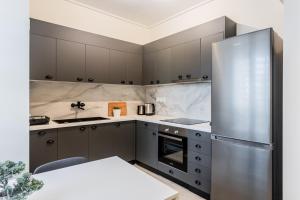 雅典Radiant 2BR Apartment in Neo Psichiko by UPSTREET的厨房配有灰色橱柜和不锈钢冰箱